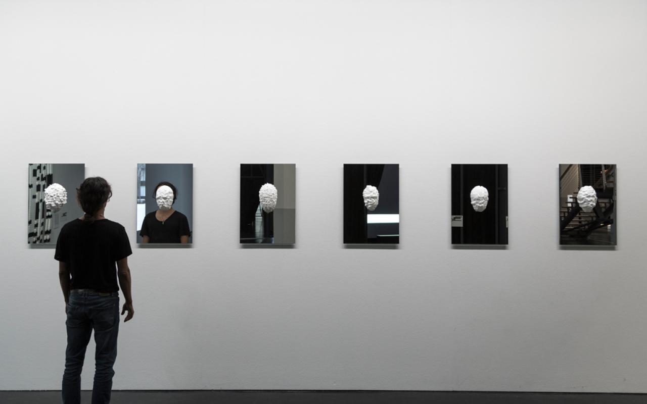 In plaster casted masks hang on mirrors