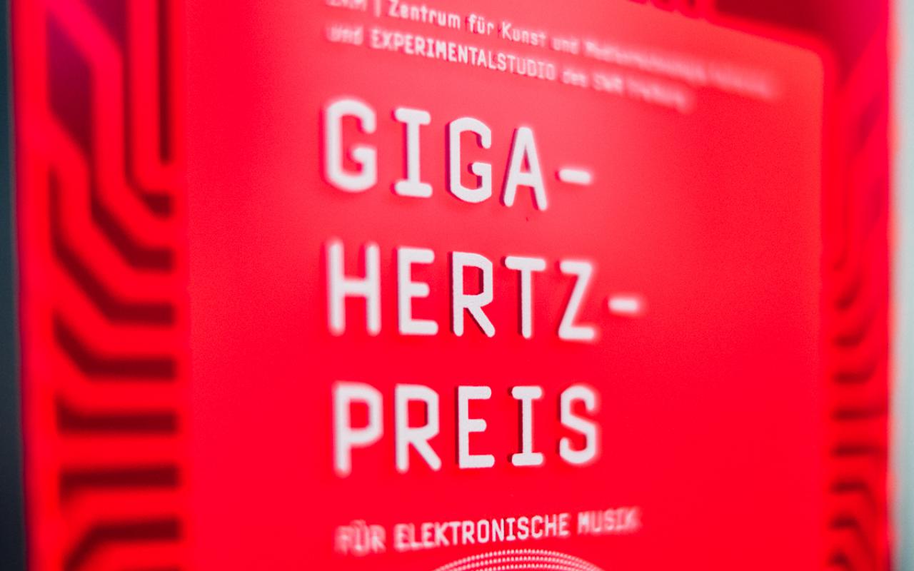 Roter Plakette, auf der mit weißer Schrift "Giga-Hertz-Preis" steht