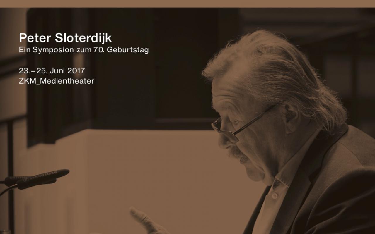 Photo of Peter Sloterdijk during a lecture, sitting at a table.