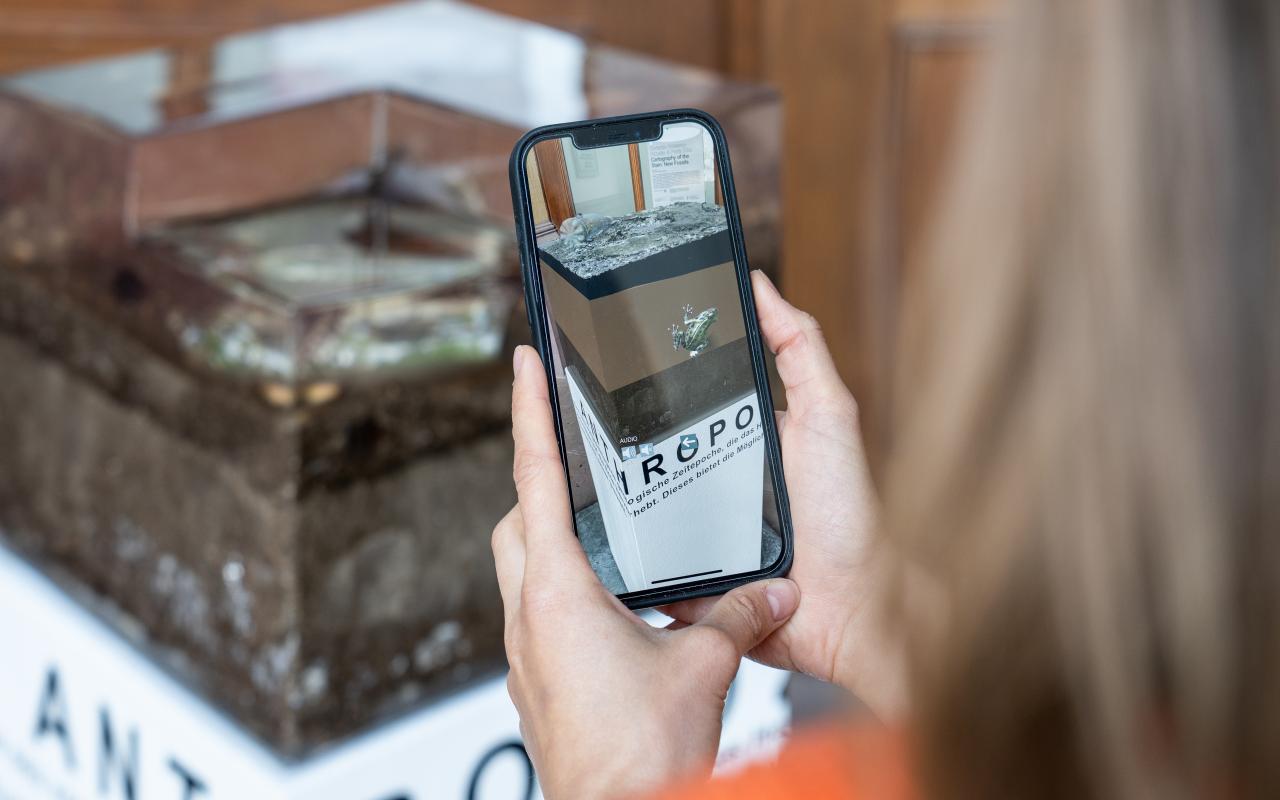You can see a person viewing the installation using AR via smartphone