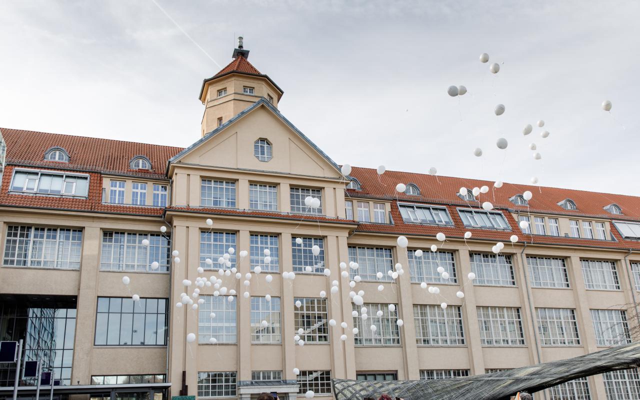 Weiße Luftballons steigen vor dem ZKM Gebäude auf.