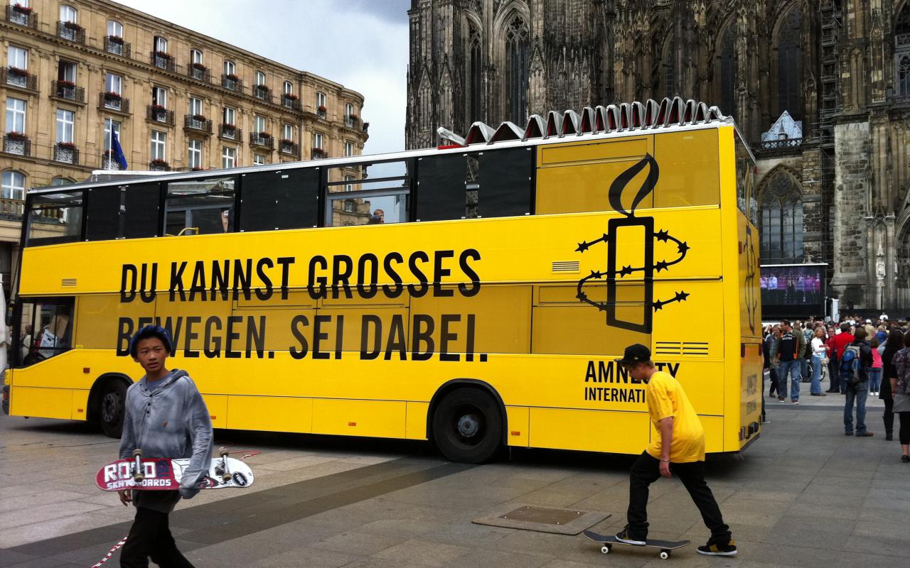 Gelber Doppeldeckerbus von Amnesty International
