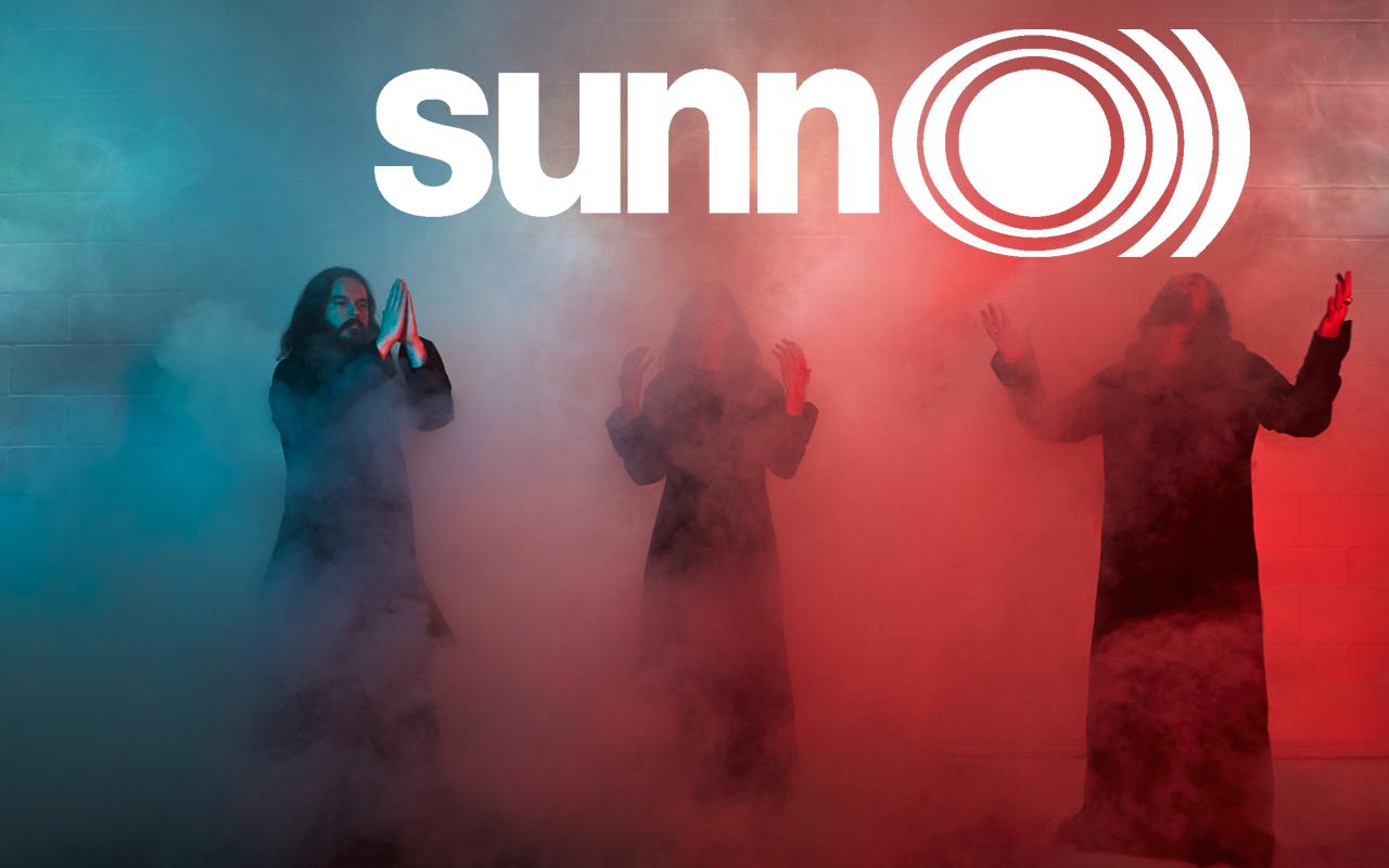 The three musicians of the metal band »Sunn O)))« are standing in blue, white and red fog.