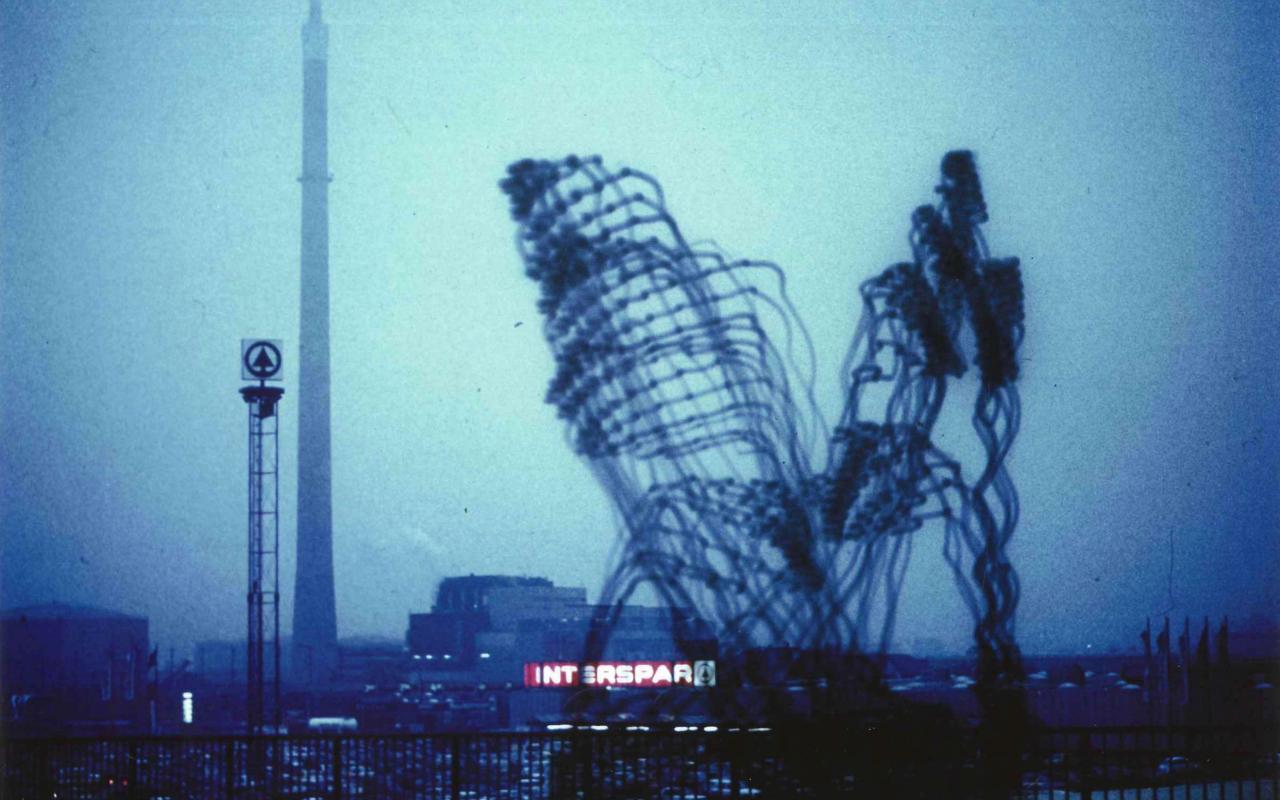 »Imaginäre Architekturen« von Otto Beckmann. Zu sehen ist eine trübe Skyline. Zwei große, figürliche Architekturen bilden das Hauptmerkmal. 