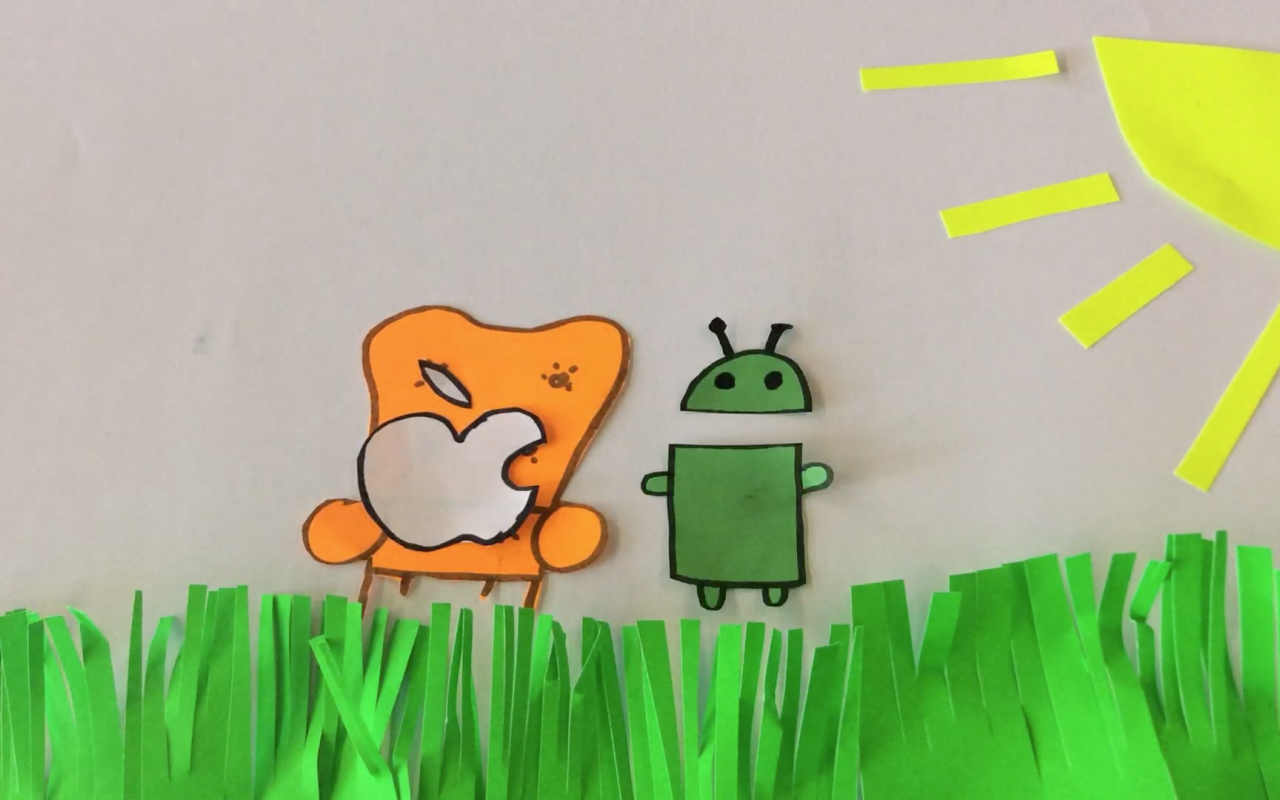 Still of an animation workshop in which the bitten apple sits on a cosy chair next to the android-mascot.