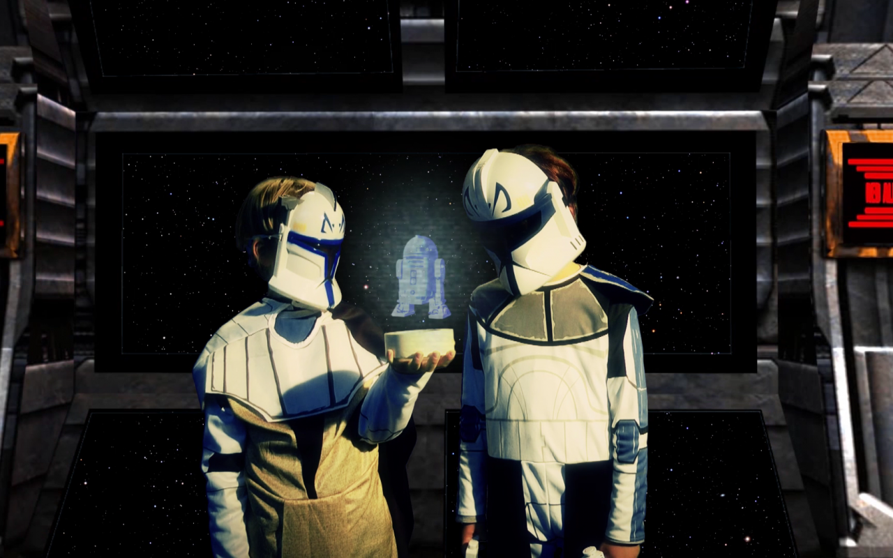 Two kids in disguise are standing next to each other and are wearing white roboter masks. Between them is a holographic image digitally added and the boys are looking at it.
