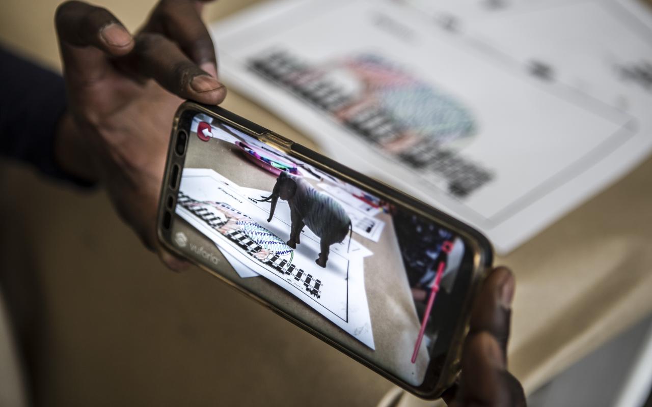 Auf einem Handydisplay erscheint ein Elefant in Augmented Reality