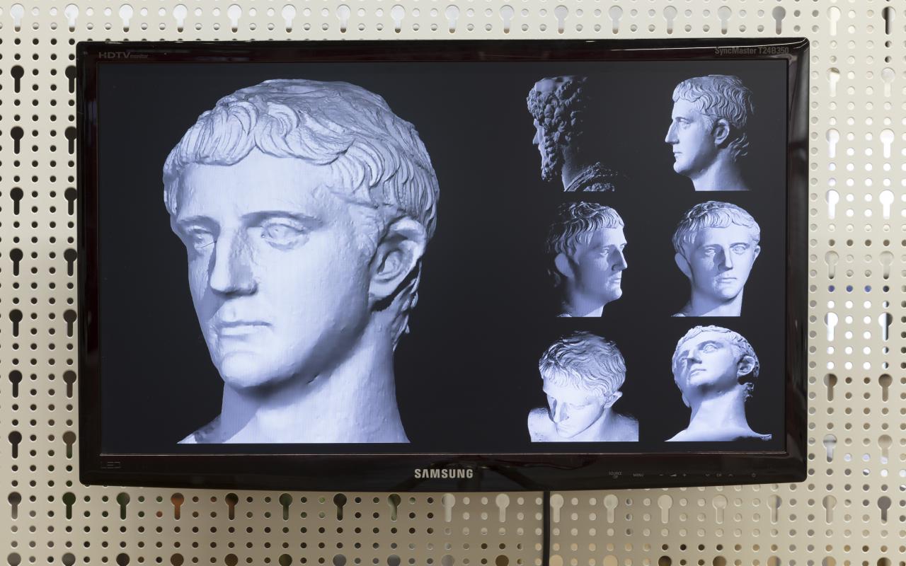 Different views of an antique statue on a flat screen monitor.