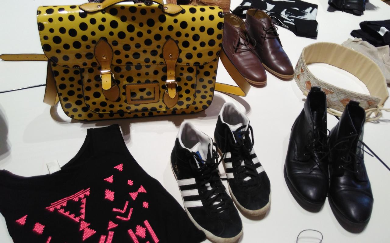 You can see a yellow dotted bag surrounded by shoes and a t-shirt.