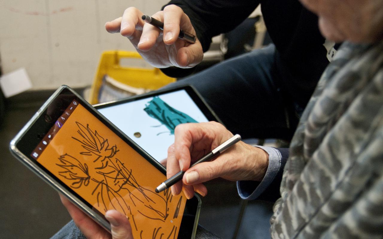 Someone is painting with a stylus, a special pen for displays, on an iPad.
