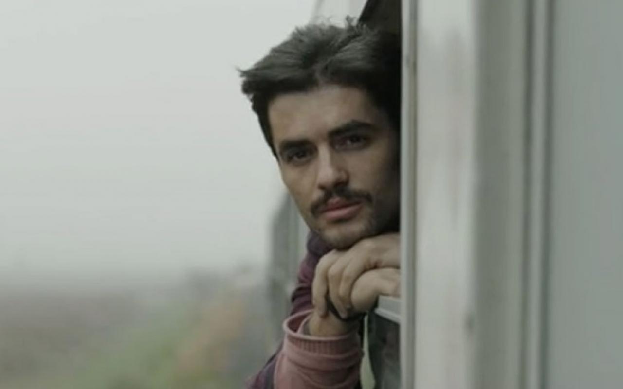 Filmstill from »Zer«: A young man looking out of a train