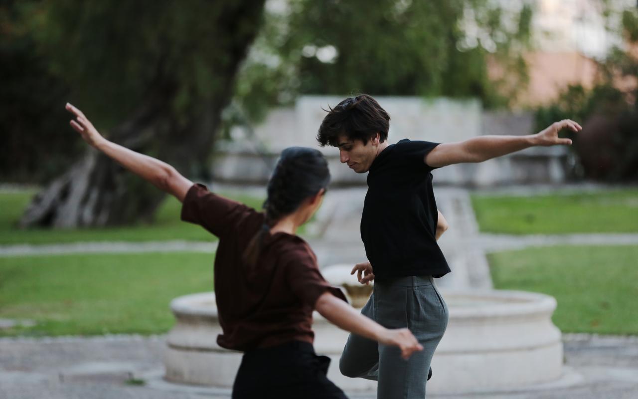Zu sehen sind zwei Personen in einem Park, die miteinander tanzen.