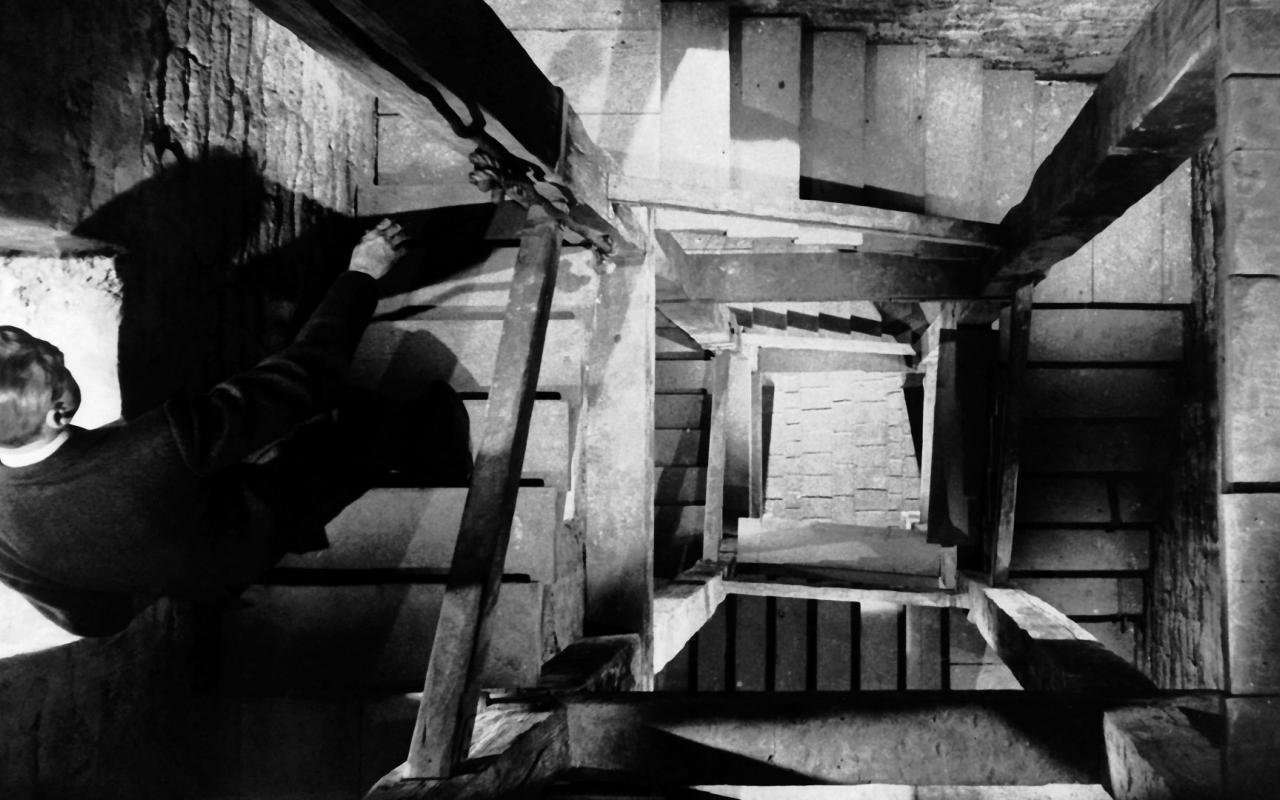 Standbild aus Alfred Hitchcocks »Vertigo« - EIn man geht eine hohe Treppe hinunter
