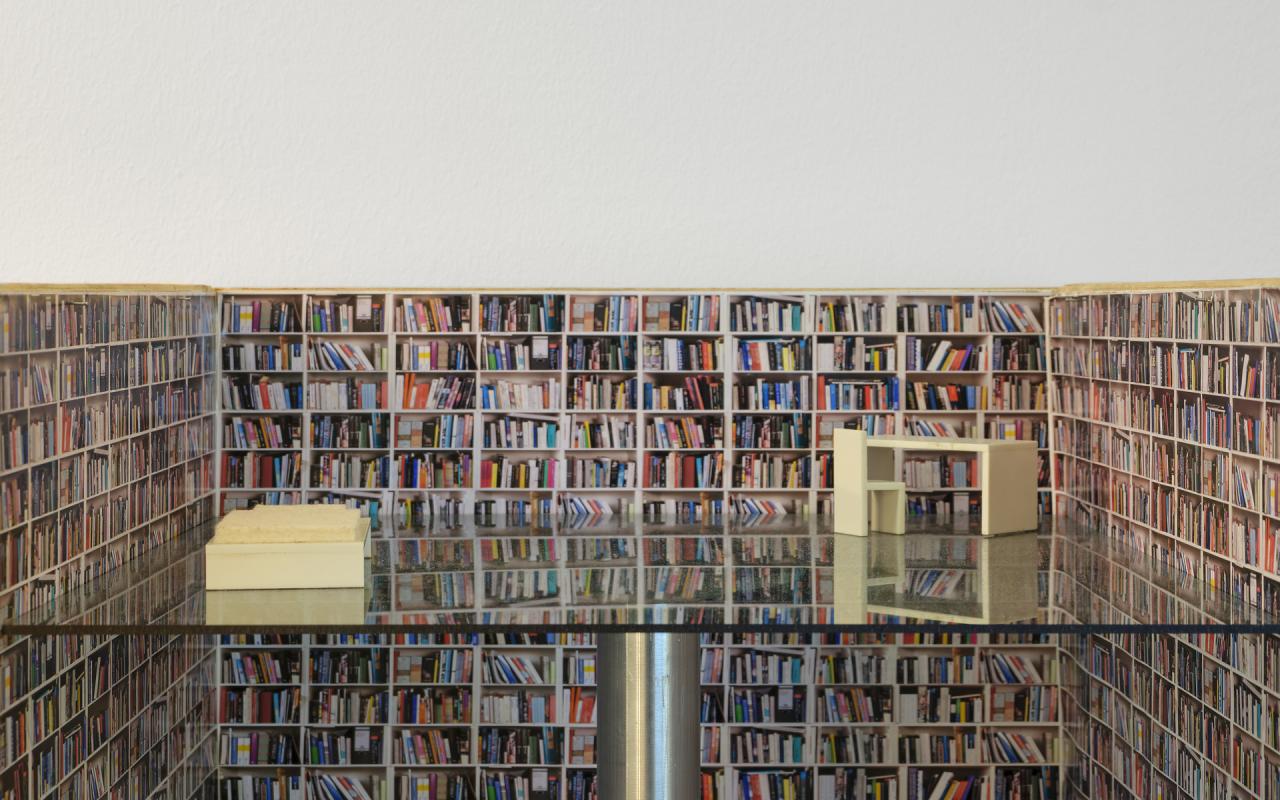 Architekturmodell: Ein Lift in einem mit Bücher gefüllten Turm, der nicht nur Lift, sondern auch Wohn- und Arbeitsraum ist. 