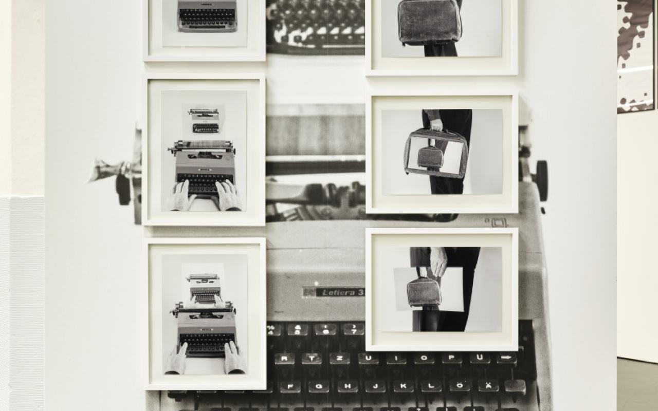 The photo shows a black and white photo collage. The background is formed by an old typewriter and on it hang 6 framed black and white pictures that alternately show a briefcase and a typewriter.