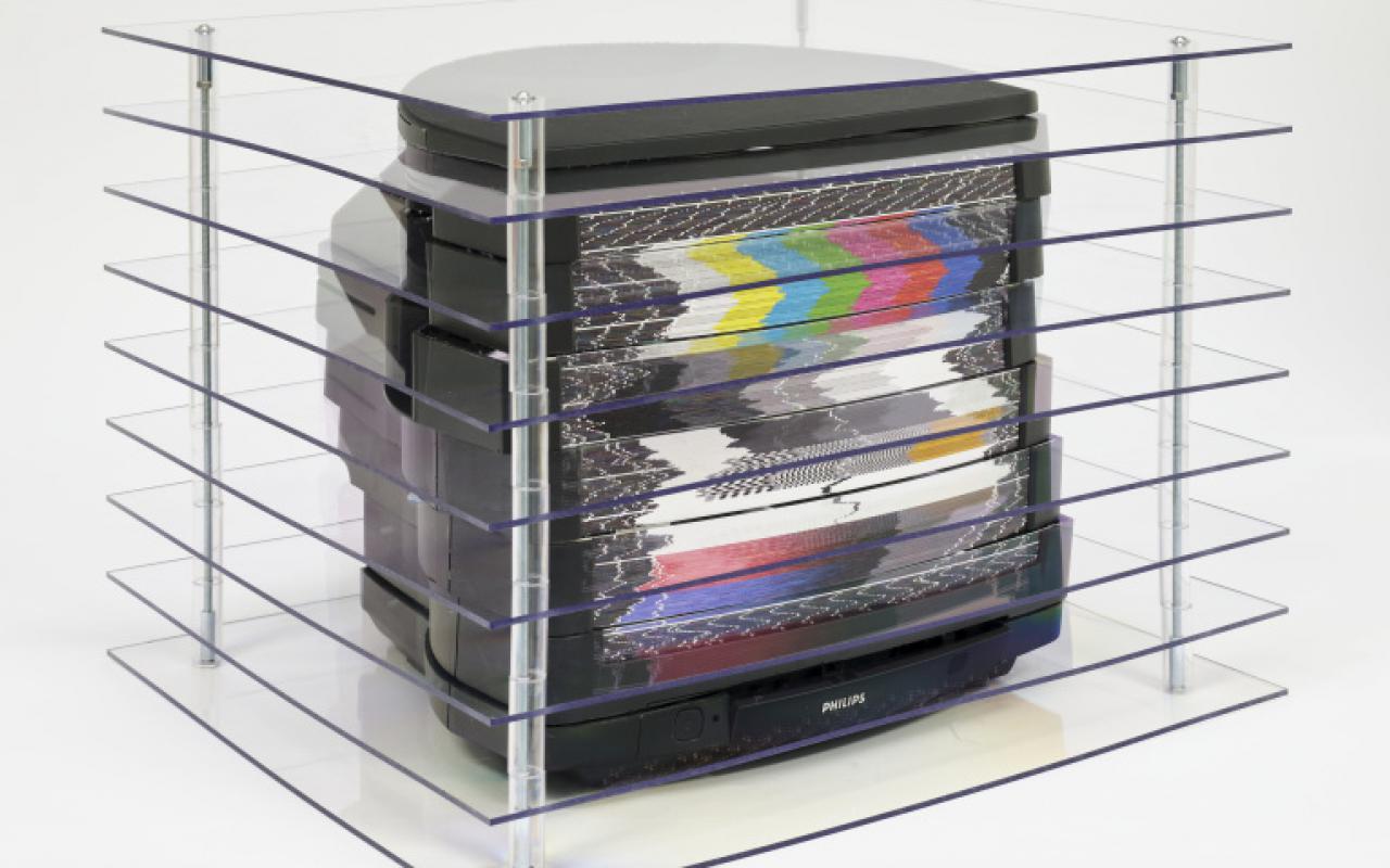 Das Foto zeigt einen zerschnittenen Röhrenbildschirm deren einzelne Schichten mit Plexiglas voneinander getrennt werden. Auf dem Bildschirm sind mehrere verzerrte Farbverläufe zu sehen.