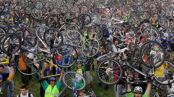 A lot of people are holding bicycles to the sky