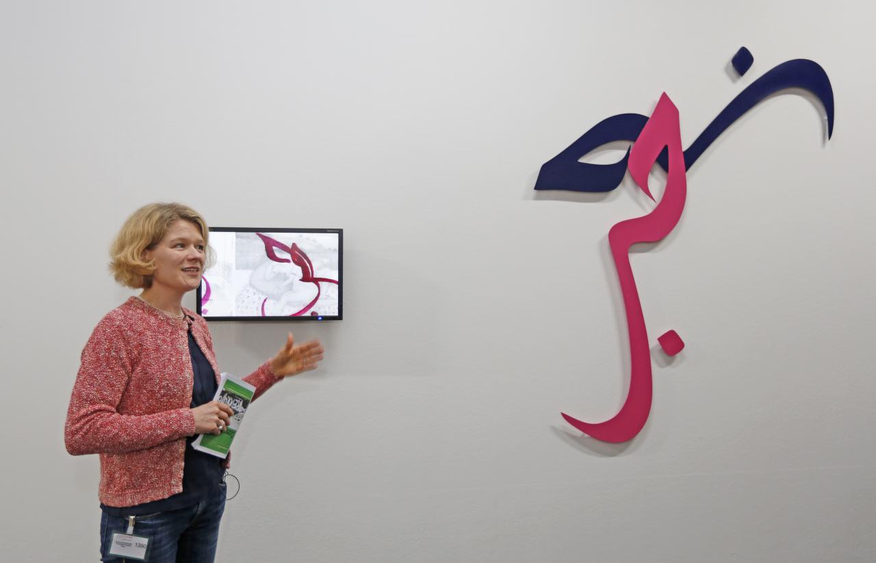 A Woman stands in front of an artwork