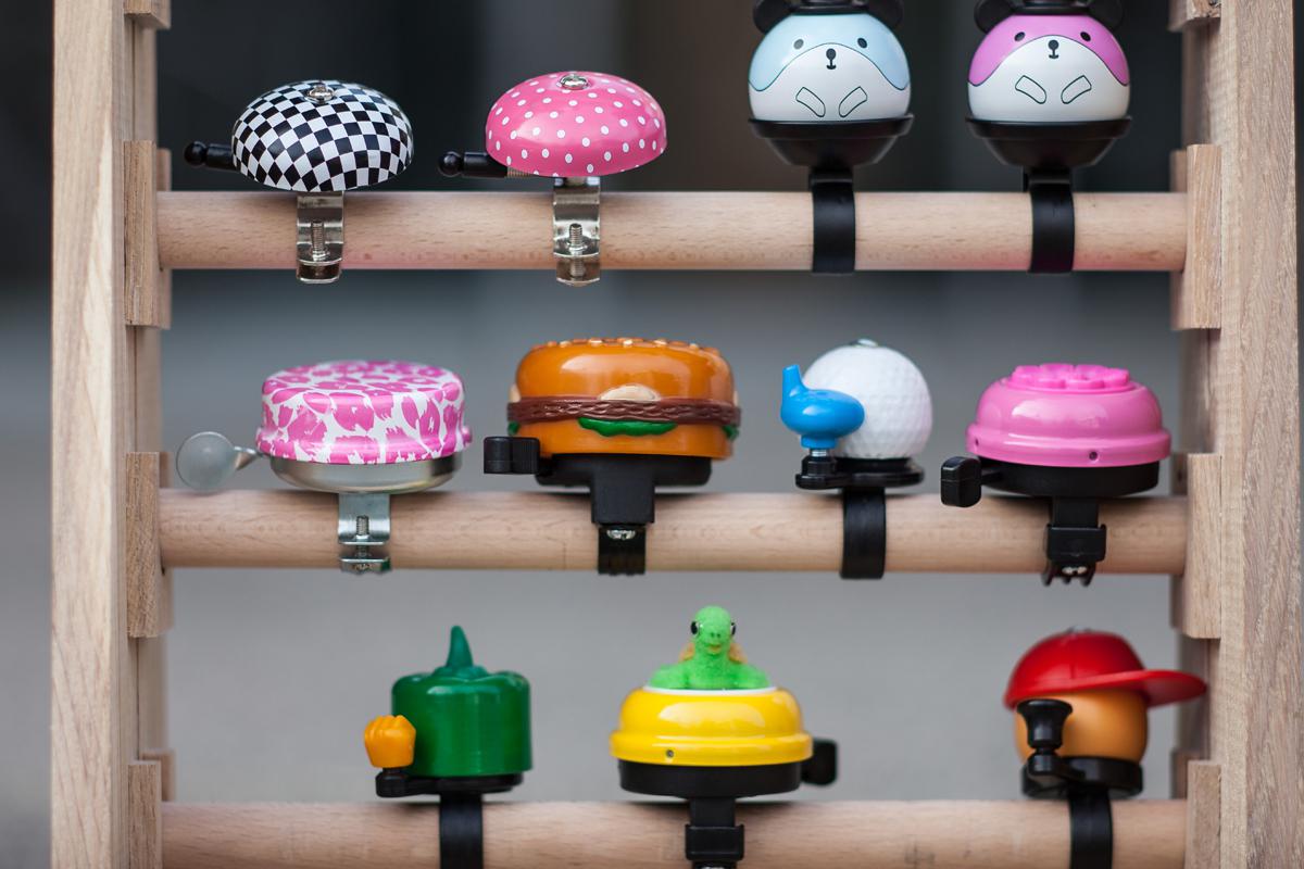 A shelf full of colorful, different bicycle bells