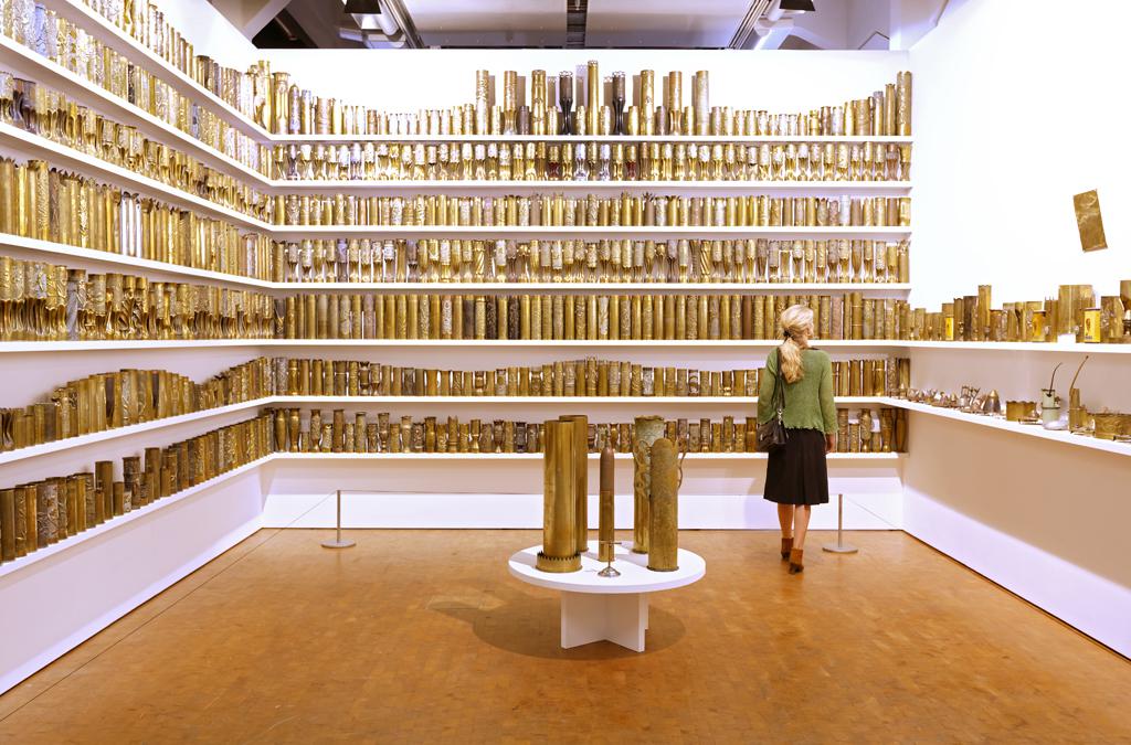 Woman is standing in front of golden exhibition objects