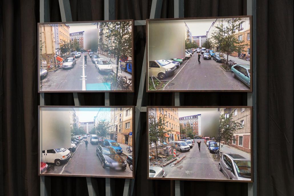 Vier Bildschirme über und nebeneinander, die Überwachungsvideos einer Straße zeigen