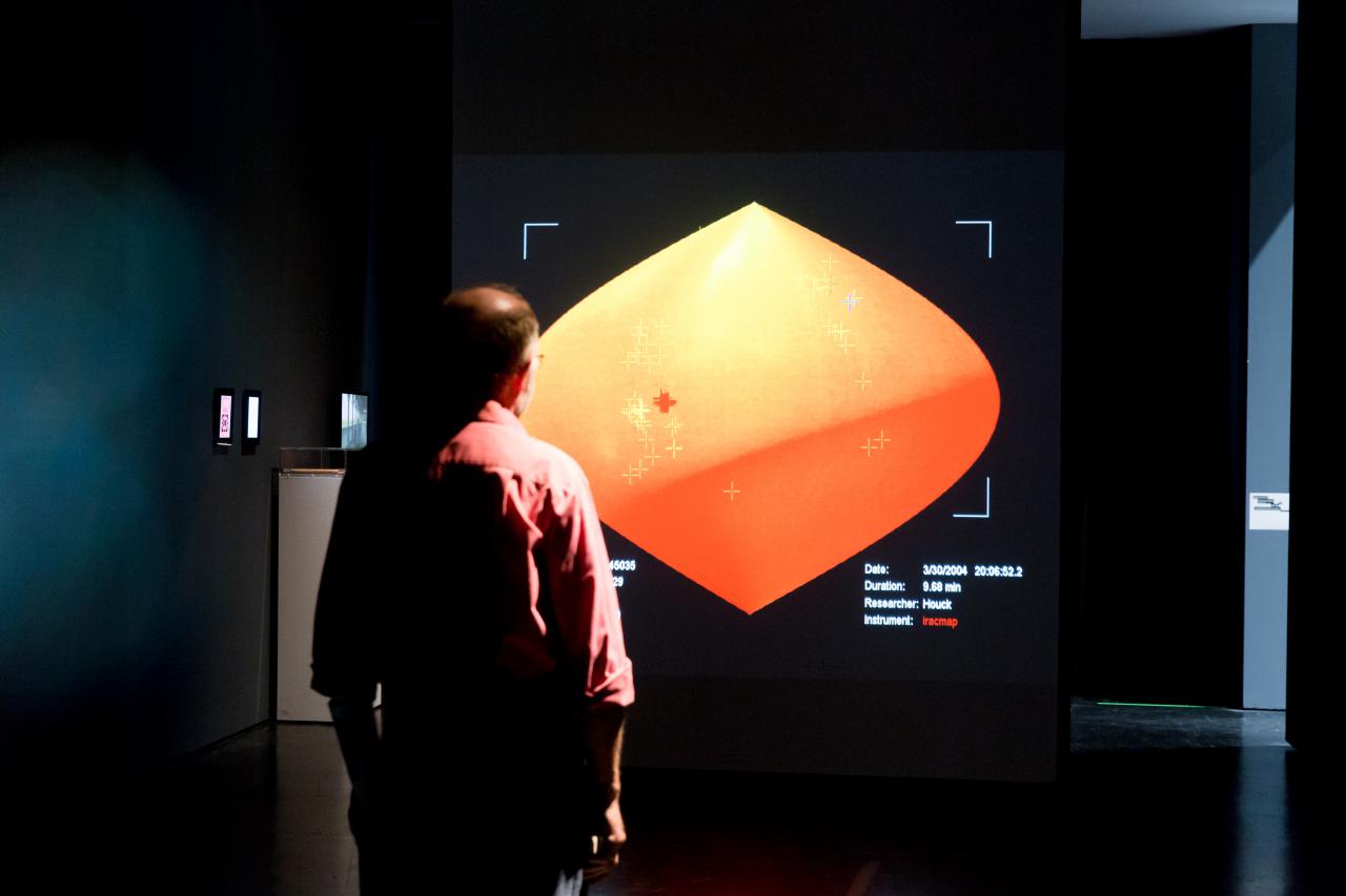 A man stands in front of a representation of the room with an infrared camera