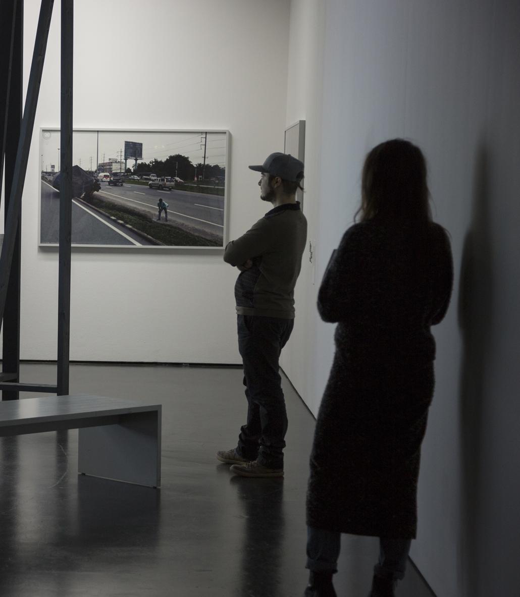 Two persons look at a picture at the wall
