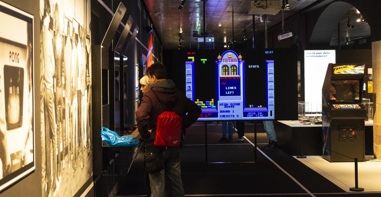 Zwei Menschen stehen vor einem Bildschirm im Ausstellungsraum »zkm_gameplay«.