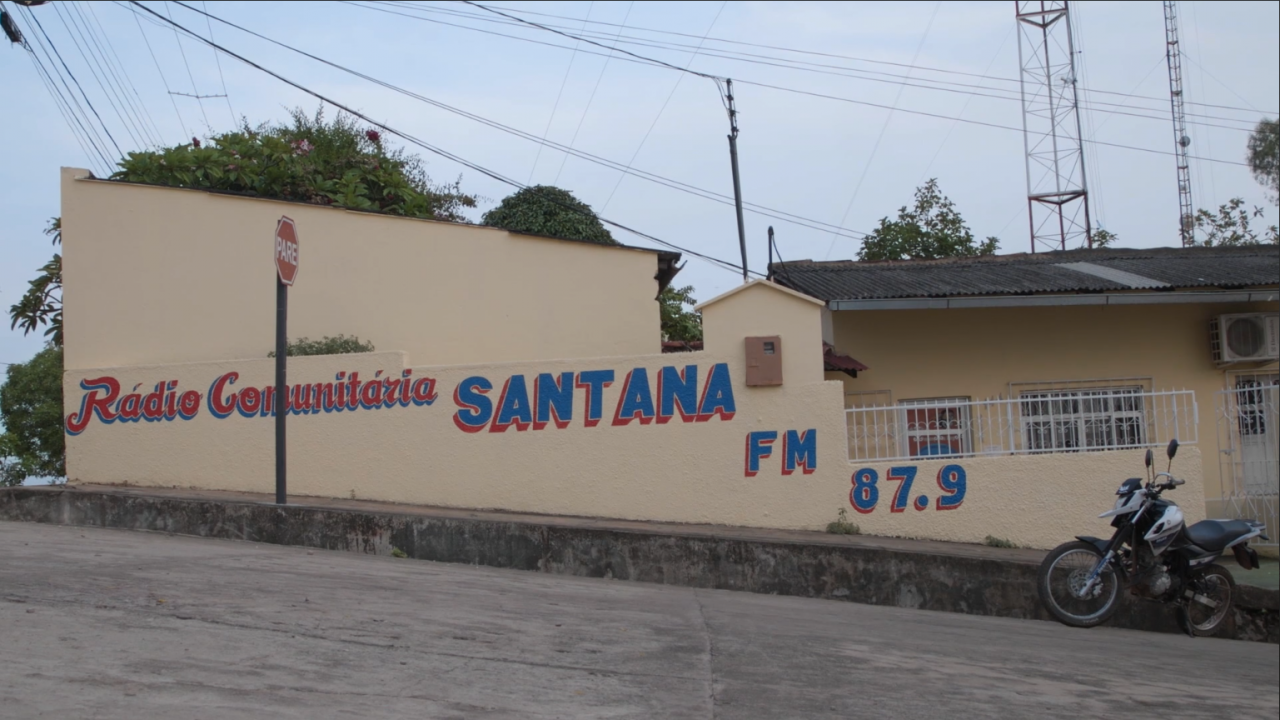 Zu sehen ist eine Häuserwand auf der steht "Radio Comunitaria Santana FM 87.9".