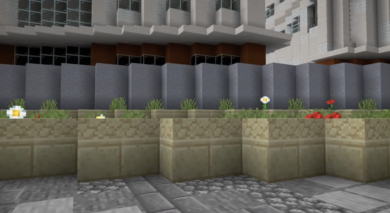 Minecraft view of a representation of the urban space. House facades are shown in the background. In the foreground, plants are placed in front of a wall.