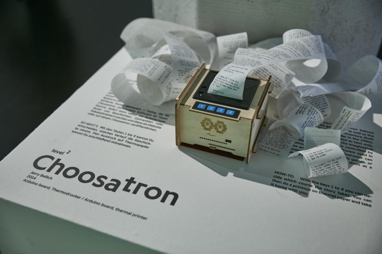 Eine Holzbox mit einem Drucker, Vier-Tasten Interface und ausgedruckten Text