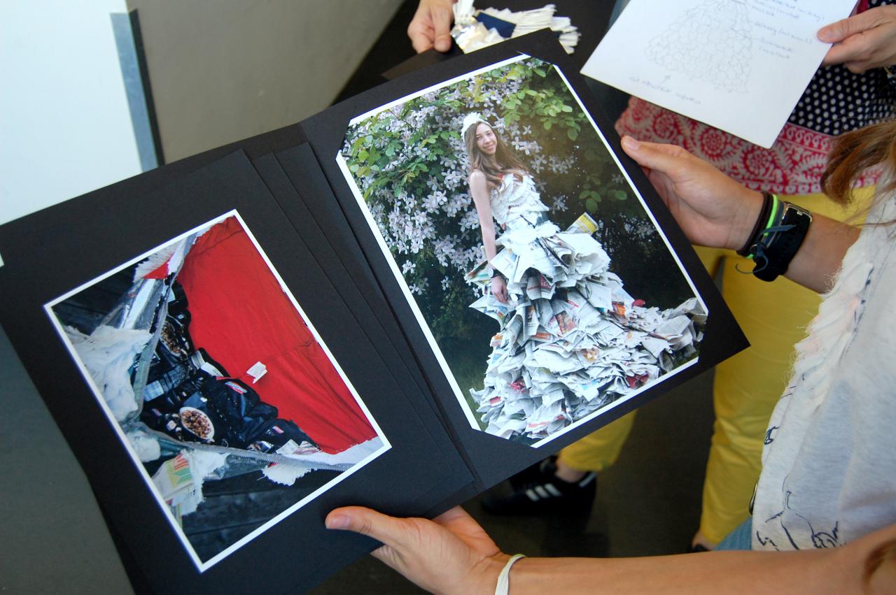 Eine junge Schülerin präsentiert ihre eingerahmten Fotografien im Rahmen einer Veranstaltung der Kulturakademie.