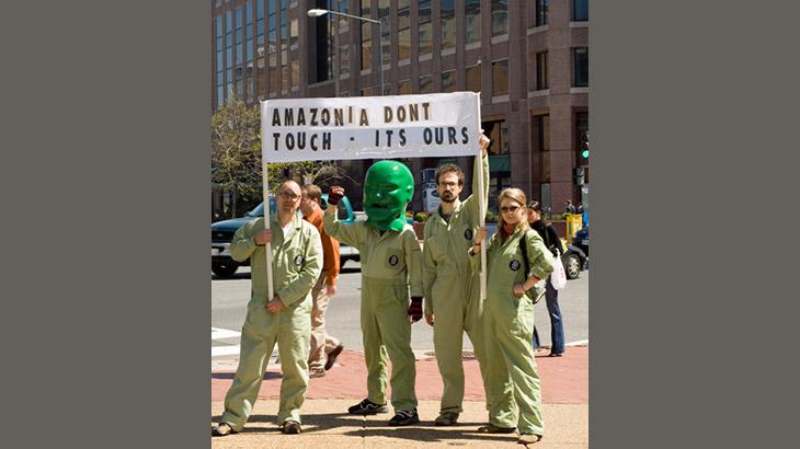 Vier Menschen halten ein Banner hoch auf dem steht "Amazonia dont touch - its ours"