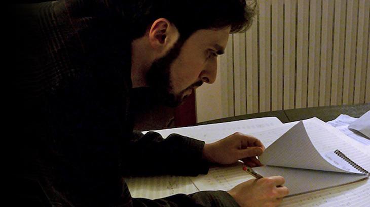 A man writes on a writing pad
