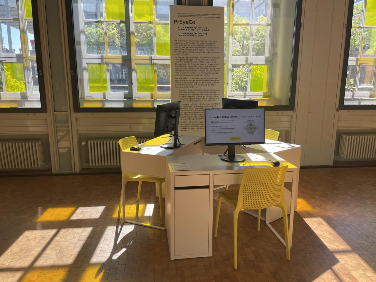 Exhibition view of the object PrEyeCo; three desks with computers and yellow chairs