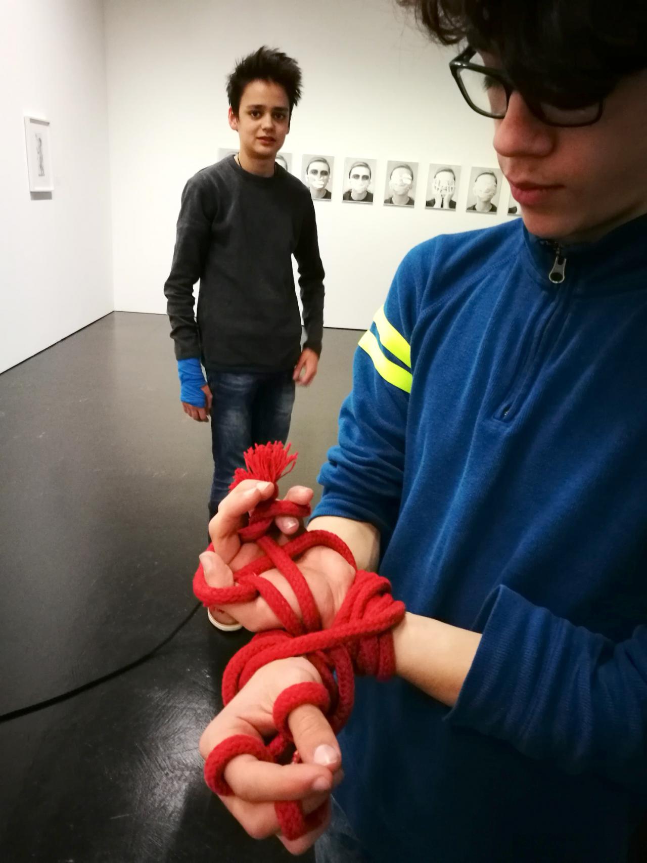 Zu sehen sind die Hände eines Schülers mit einem roten Seil geknebelt im Rahmen der Veranstaltung »Art im Puls«.