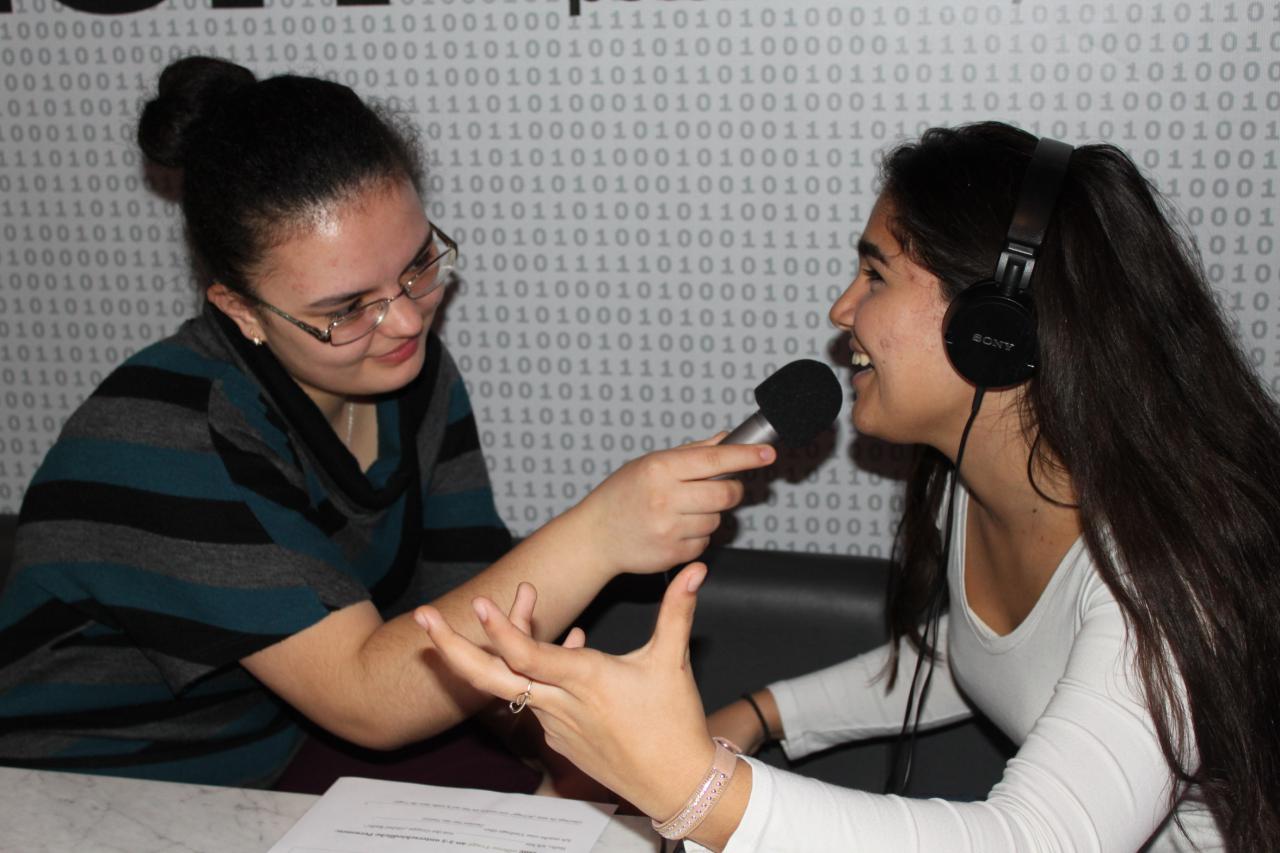 Zwei Schülerinnen die sich gegenseitig interviewen im Rahmen der Veranstaltung »Global Sound«. 