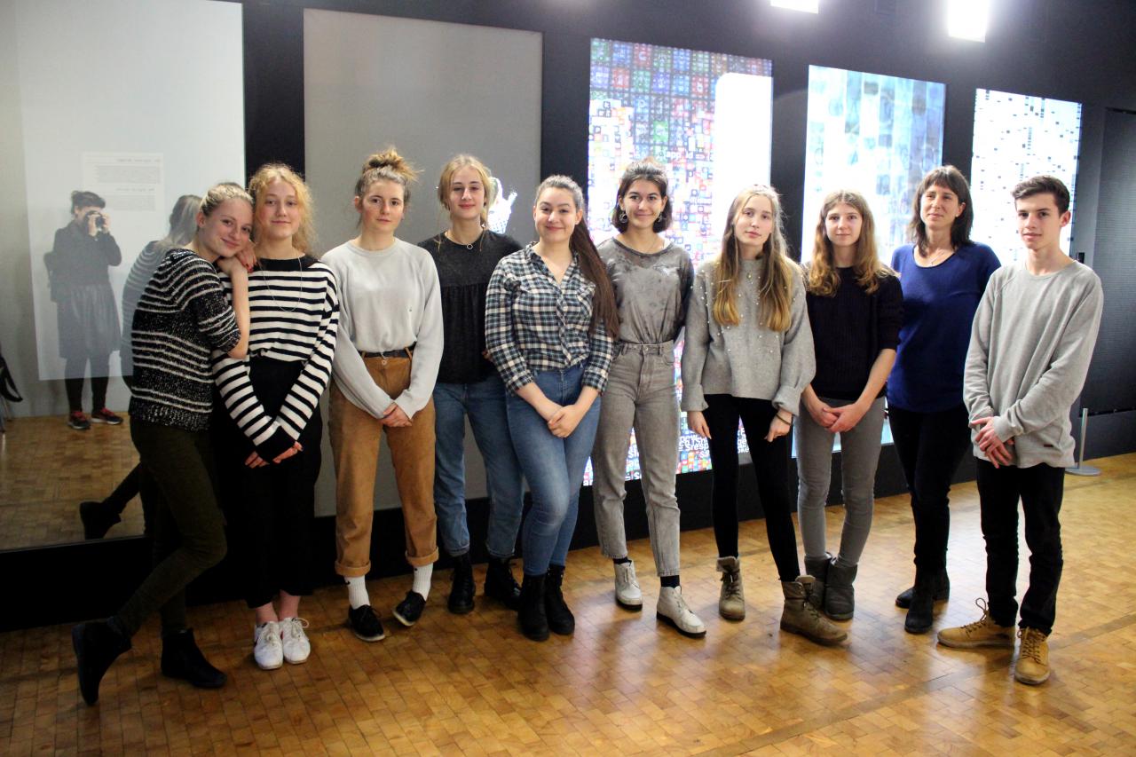 A group of pupils stand in front of a work of art as part of the »Art im Puls« event.