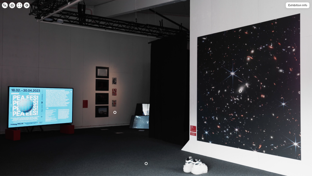 Blick in einen Ausstellungsraum, mit einem großen Bildschirm mit Informationstext auf der linken Seite, daneben mehrere Gemälde und Fotografien an der Wand. Auf der rechten Seite des Ausstellungsraum ist ein großes Bild mit funkelnden Sternen im schwarzen