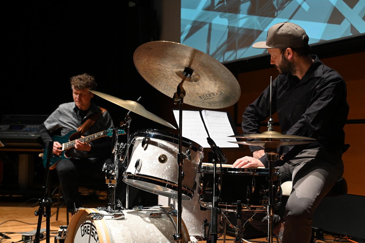 You can see the band »Polytheistic Ensemble«. Felix Schrack plays drums, behind him is another person with a guitar