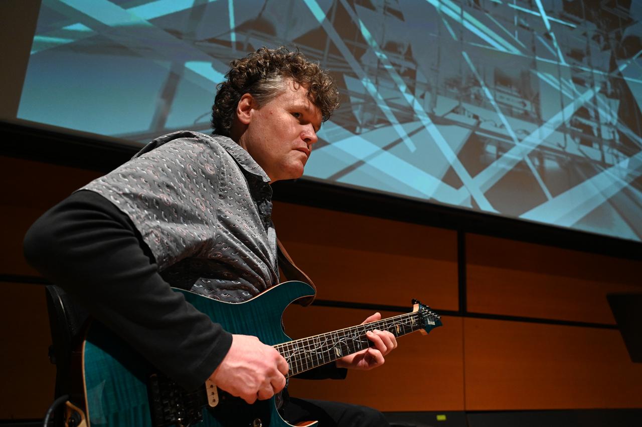 Zu sehen ist Matthias Ockert der E-Gitarre spielt von der Band »Polytheistic Ensemble«.