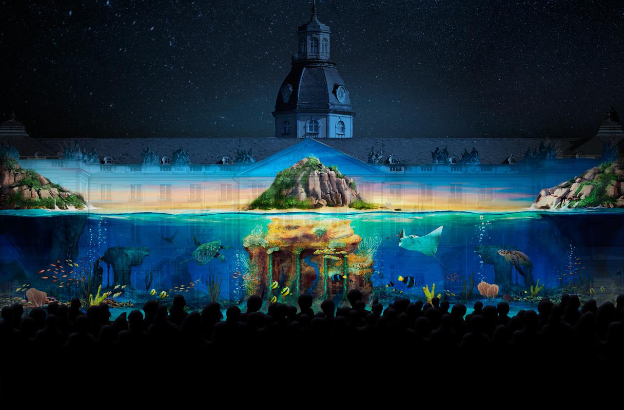 Das Foto zeigt ein Projection Mapping der Gruppe Maxin10sity auf dem Karlsruher Schloss. Zu sehen ist eine mystische Unterwasserwelt. 