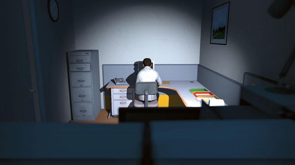 The view falls from behind on a man who is sitting at a desk in the dark