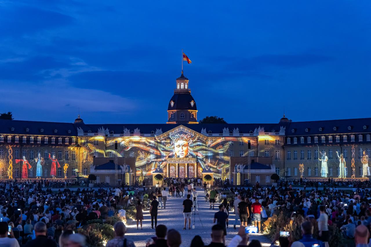 In the foreground you can see the audience that was present at the opening of the Schlosslichtspiele. Projected on the castle you can see a face reminiscent of Medusa, because the head has snakes instead of hair.