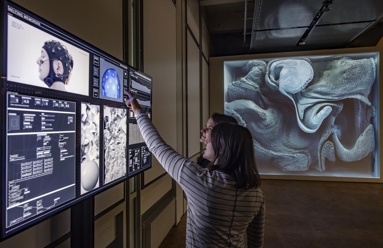 Zwei Frauen stehen vor einem Bildschirm in der Ausstellung »Open Codes. Die Welt als Datenfeld«
