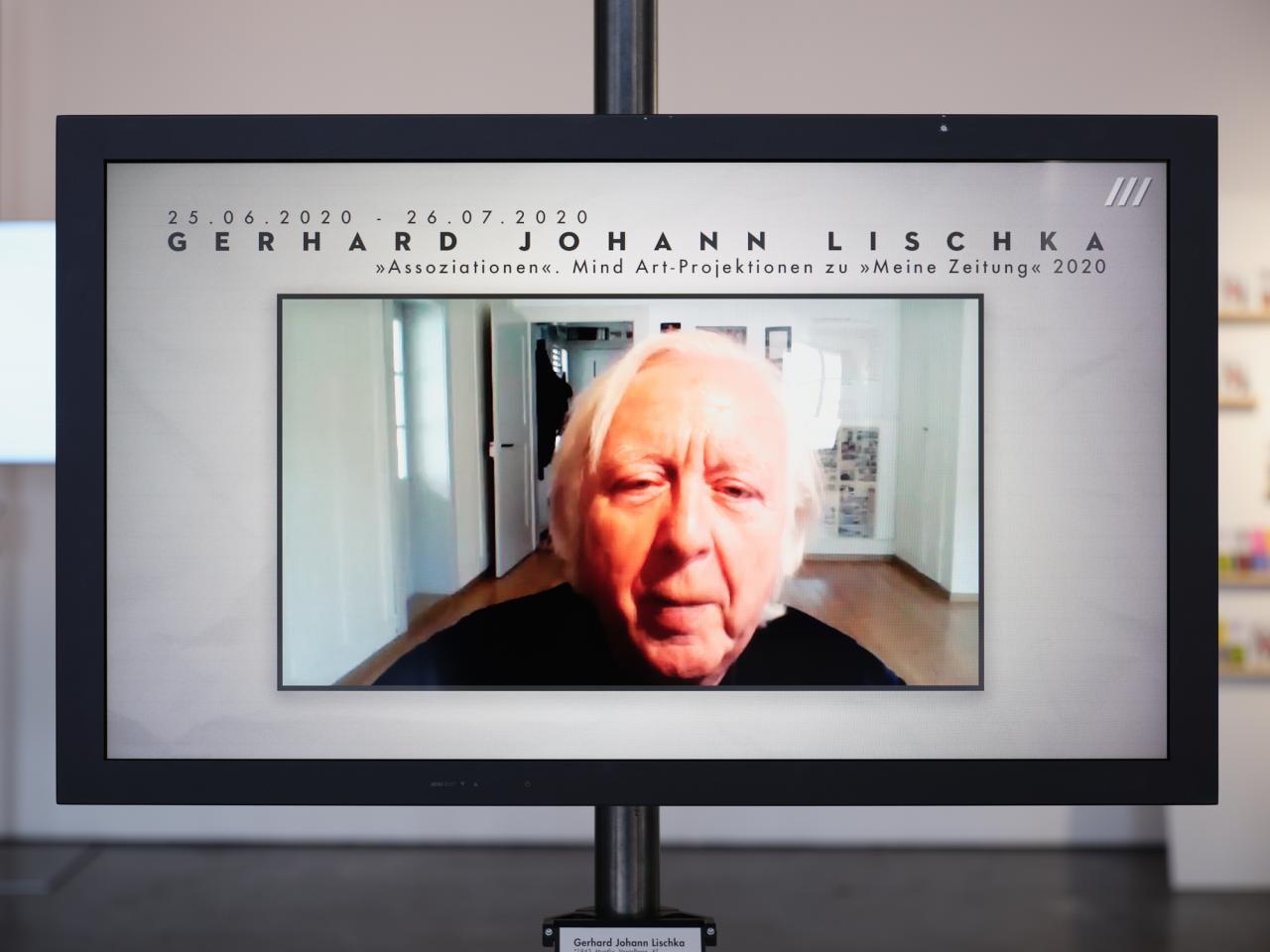 Zu sehen ist ein Bildschirm, auf dem das Gesicht eines alten Mannes spielt. Über dem Kopf des Mannes steht der Name Gerhard Johann Lischka. 