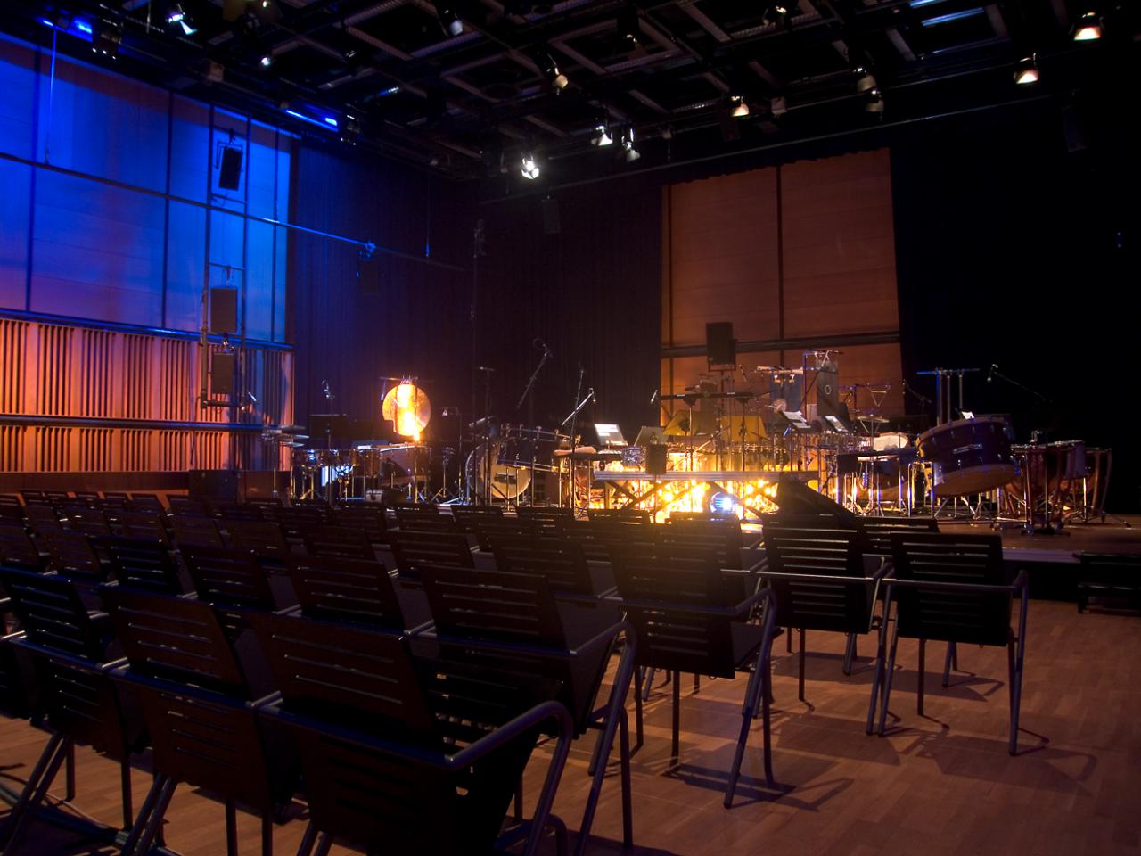 Leere Reihenbestuhlung im ZKM_Kubus mit Orchesteraufbau auf der Bühne