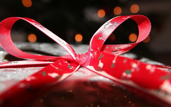 Foto eines Weihnachtsgeschenks mit roter Schleife. 
