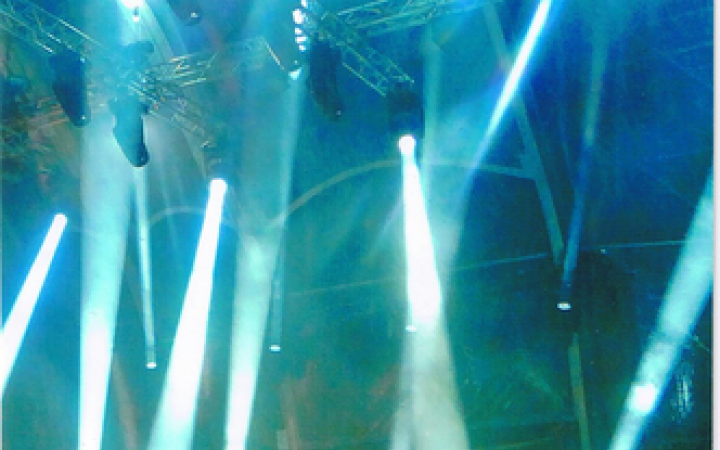 Zu sehen ist Dieter Meier auf einer blau ausgeleuchteten Bühne