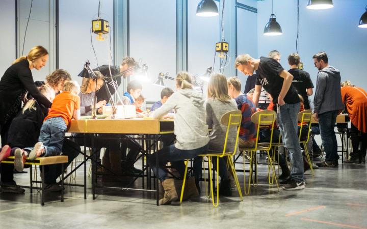 People sit at an illuminated table and work together